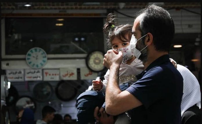 Iran-man-fixing-his-daughters-mask-against-Covid-19