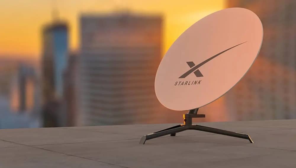 Antenë satelitore Starlink e montuar në çatinë e një ndërtese urbane gjatë perëndimit të diellit.